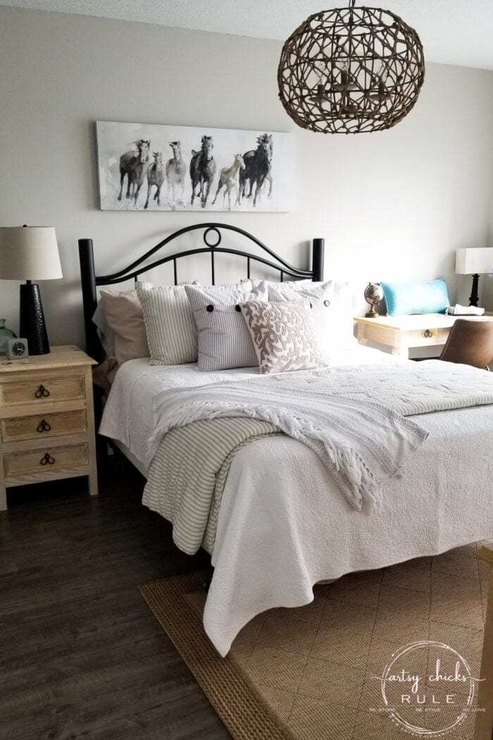Kamar tidur dengan selimut putih dan cetakan kuda di atas tempat tidur