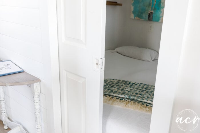 ceruk kecil dengan tempat tidur dan pintu saku setengah tertutup