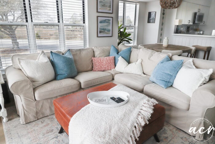 Tan sectional dengan bantal lemparan dan ottoman dan selimut