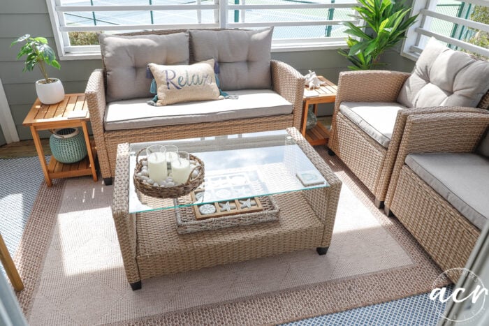 Set luar ruangan dengan meja kopi Glasstop, meja jati di setiap sisi, rileks bantal di tengah
