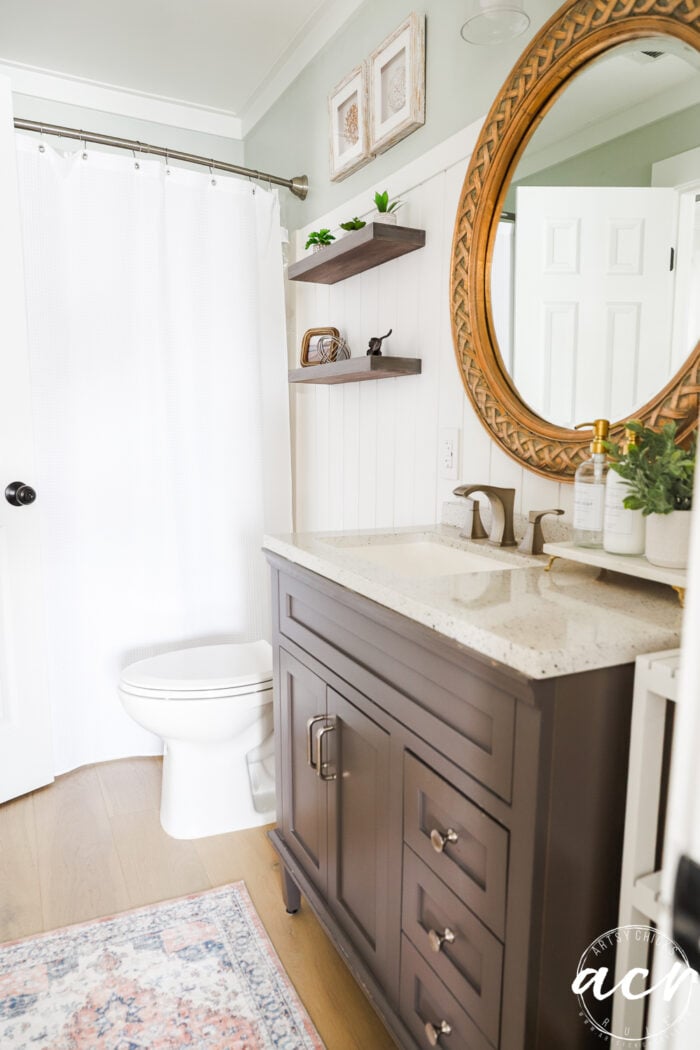 Kamar mandi yang sama dengan tirai shower putih dan karpet berwarna -warni